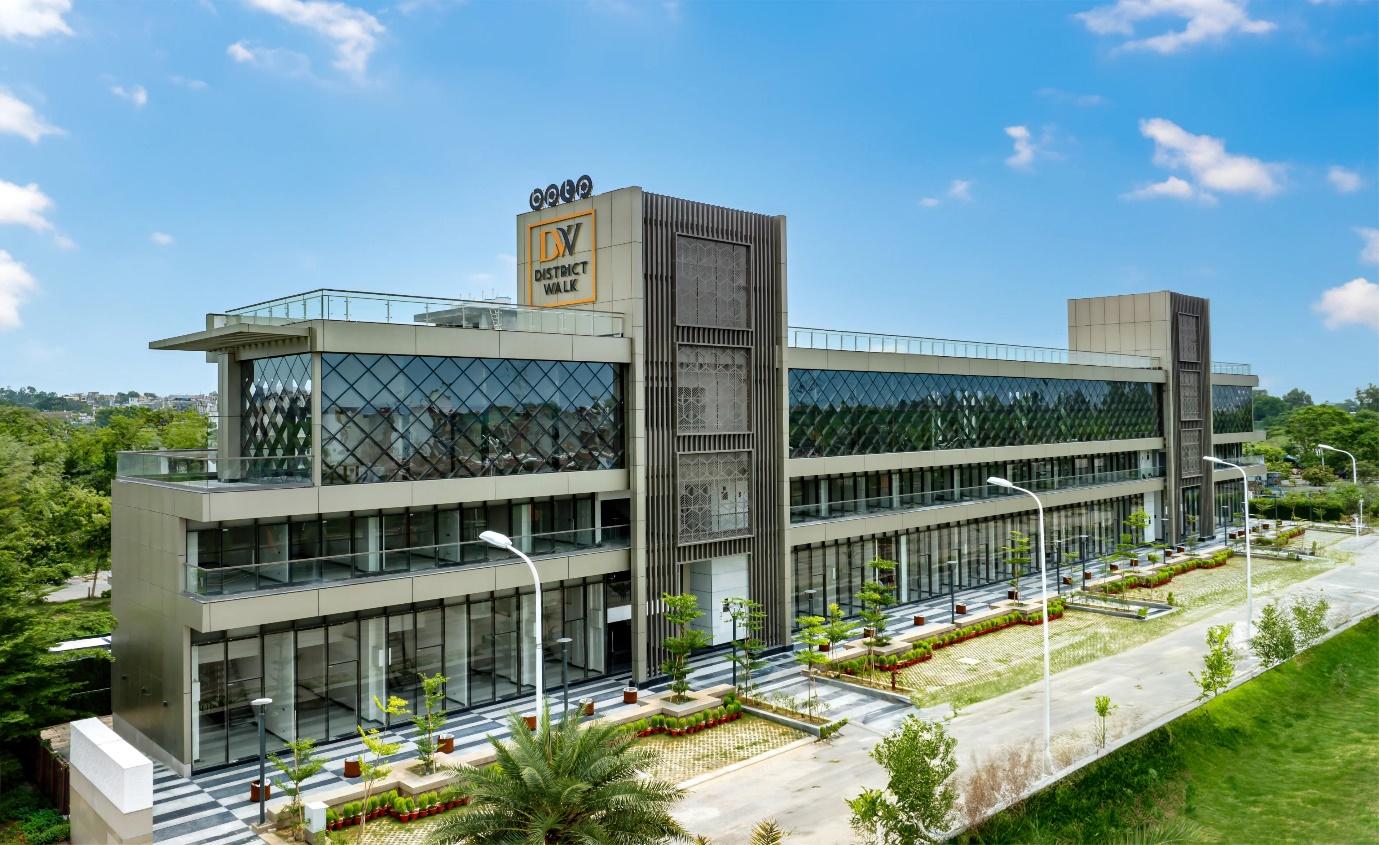 Front view of BPTP District Walk's contemporary commercial complex in Sector 81, Faridabad, showcasing its sleek glass facade and landscaped surroundings