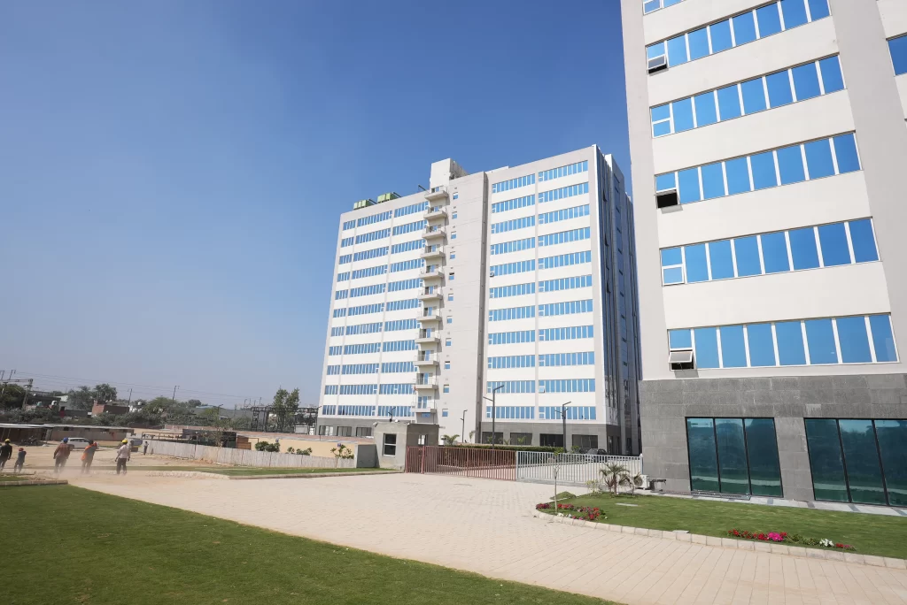 Modern glass facade commercial office tower under development in Faridabad with upcoming coworking spaces