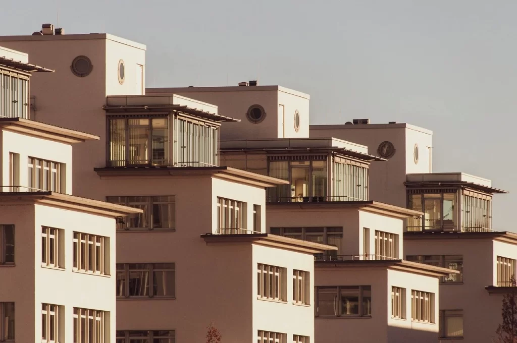 Modern residential apartment buildings with large glass balconies and geometric architecture.