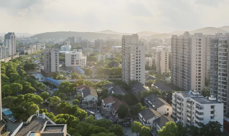 Urban residential neighborhood with mid-rise apartment buildings, greenery and cityscape under natural sunlight