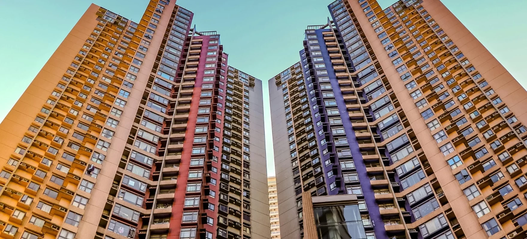 Modern high-rise residential apartment buildings in Faridabad with symmetrical architectural design and vibrant exterior colors under a clear sky